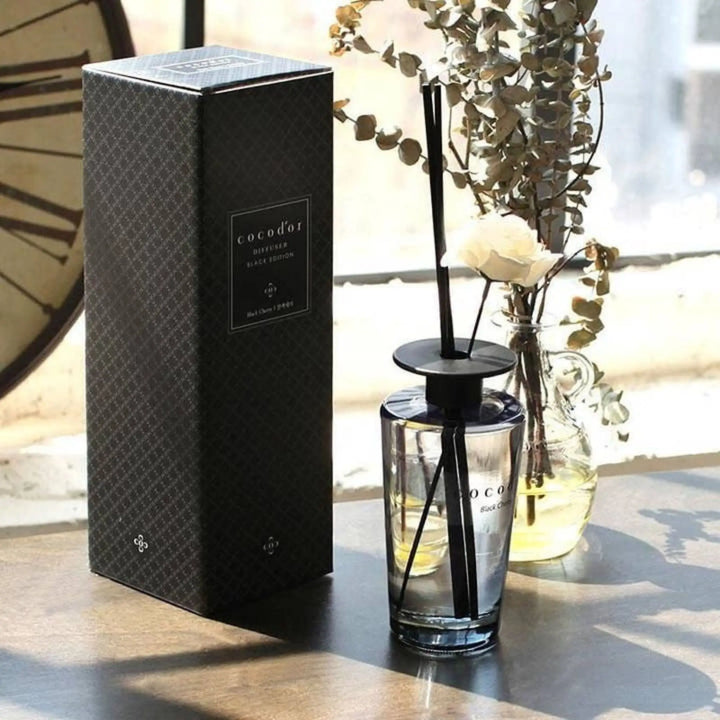 Cocodor White Musk 500ml perfume diffuser with white flower. 500 ml perfume diffuser with black sticks and white flowers.